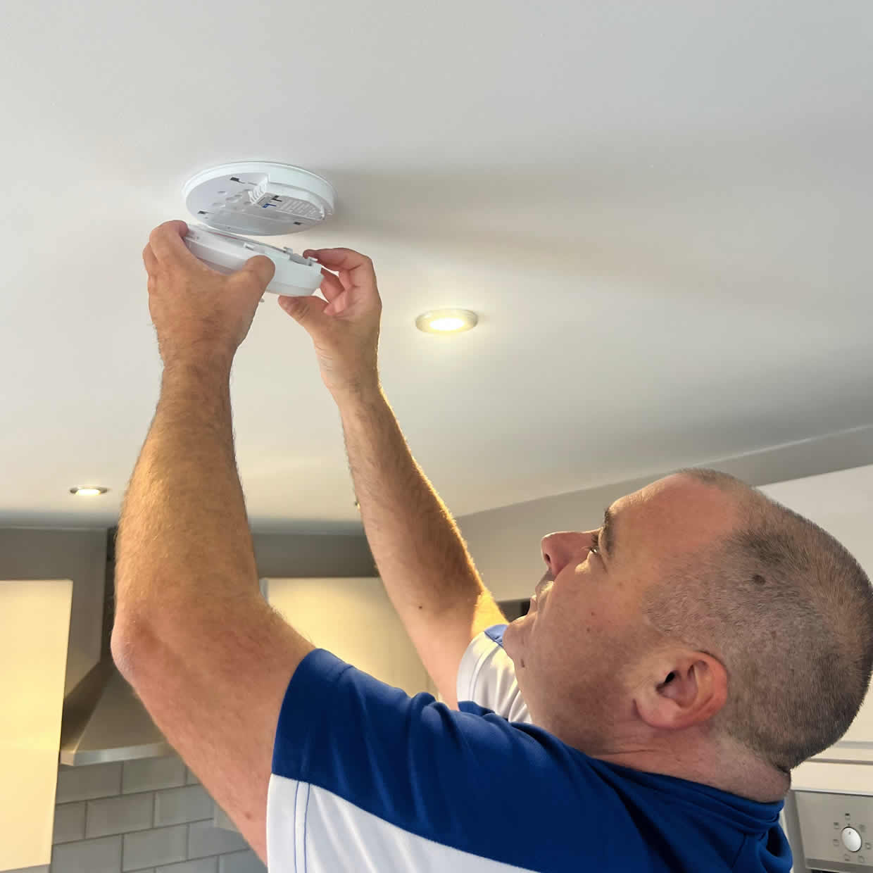 Smoke alarm being installed on a ceiling in Falkirk